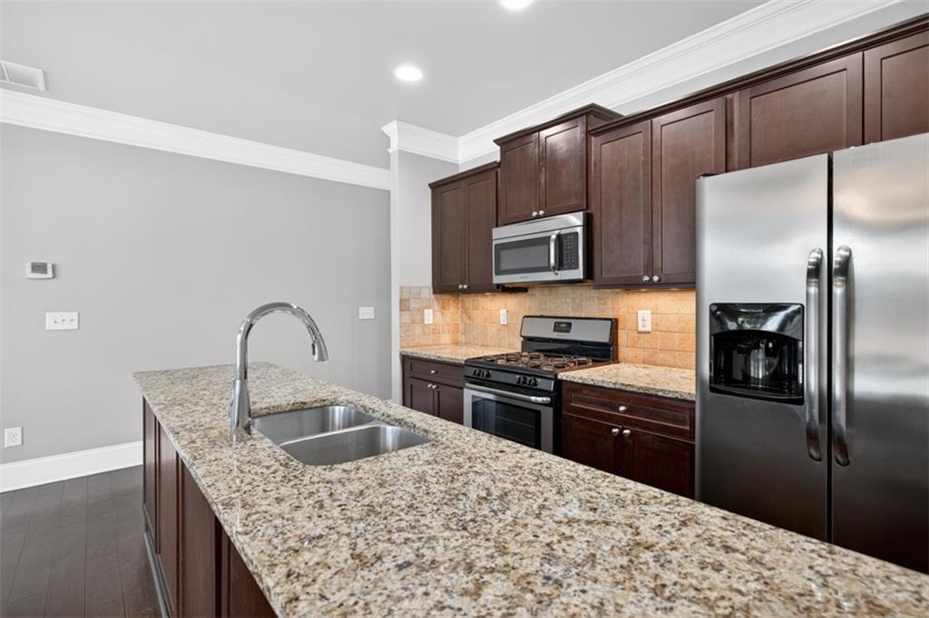 2854 Jordan Oaks Lane, Unit 8 Decatur, GA 30033 - Photo 10 of 41 a kitchen with kitchen island a counter space a sink appliances and cabinets