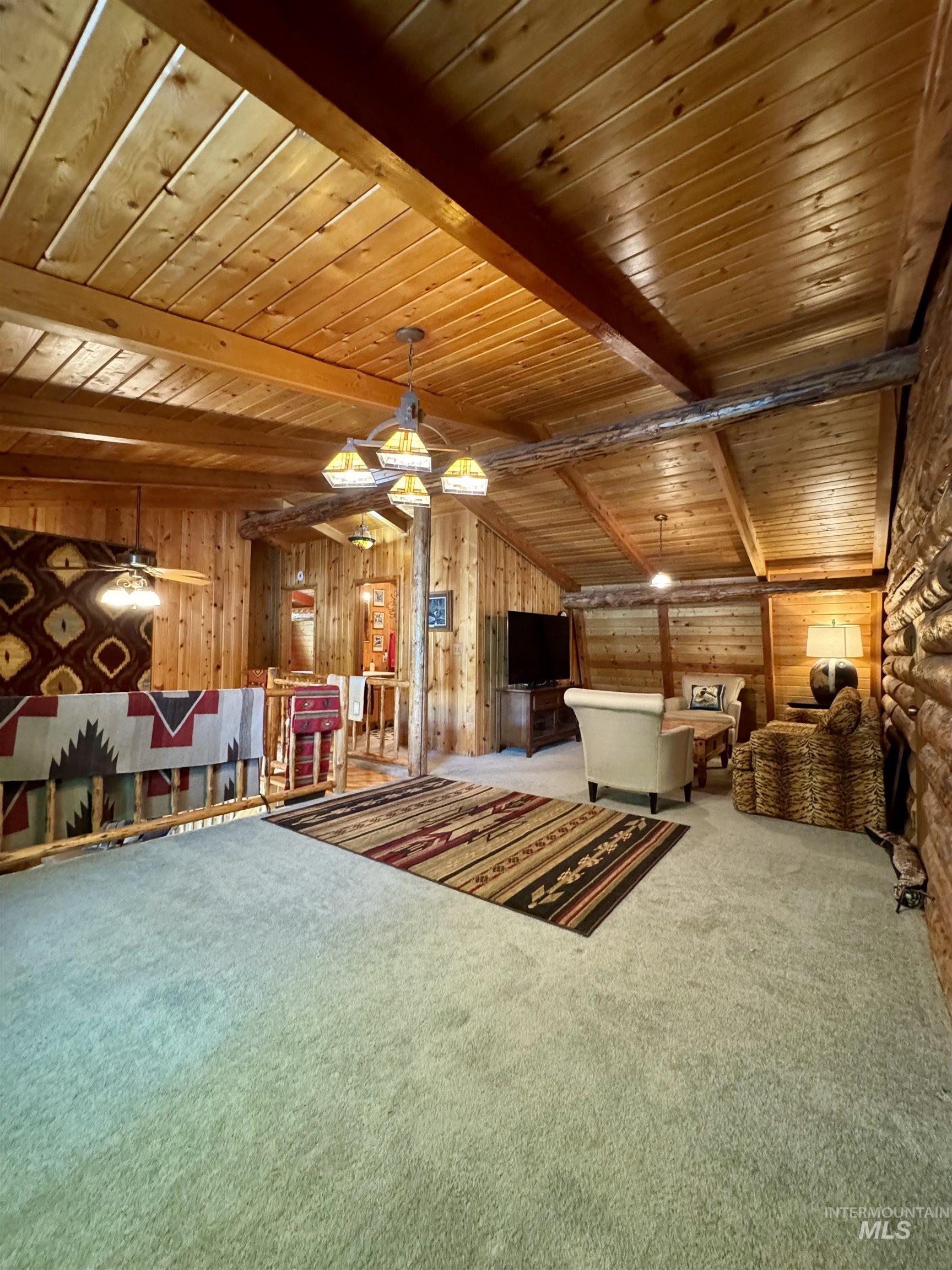 62 Bell Rapids Road Hagerman, ID 83332 - Photo 19 of 34 Carpeted loft area featuring wood-paneled walls and ceiling with exposed wood beams