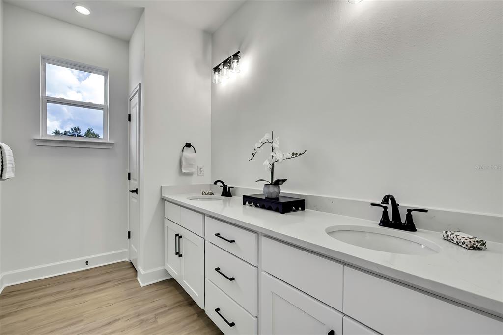 6589 Freeport Drive Spring Hill, FL 34608 - Photo 26 of 63 a bathroom with double sink and a mirror