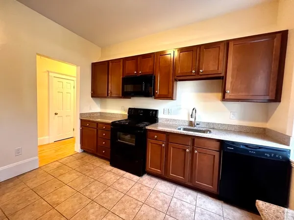 a kitchen with stainless steel appliances granite countertop a stove a sink and a microwave