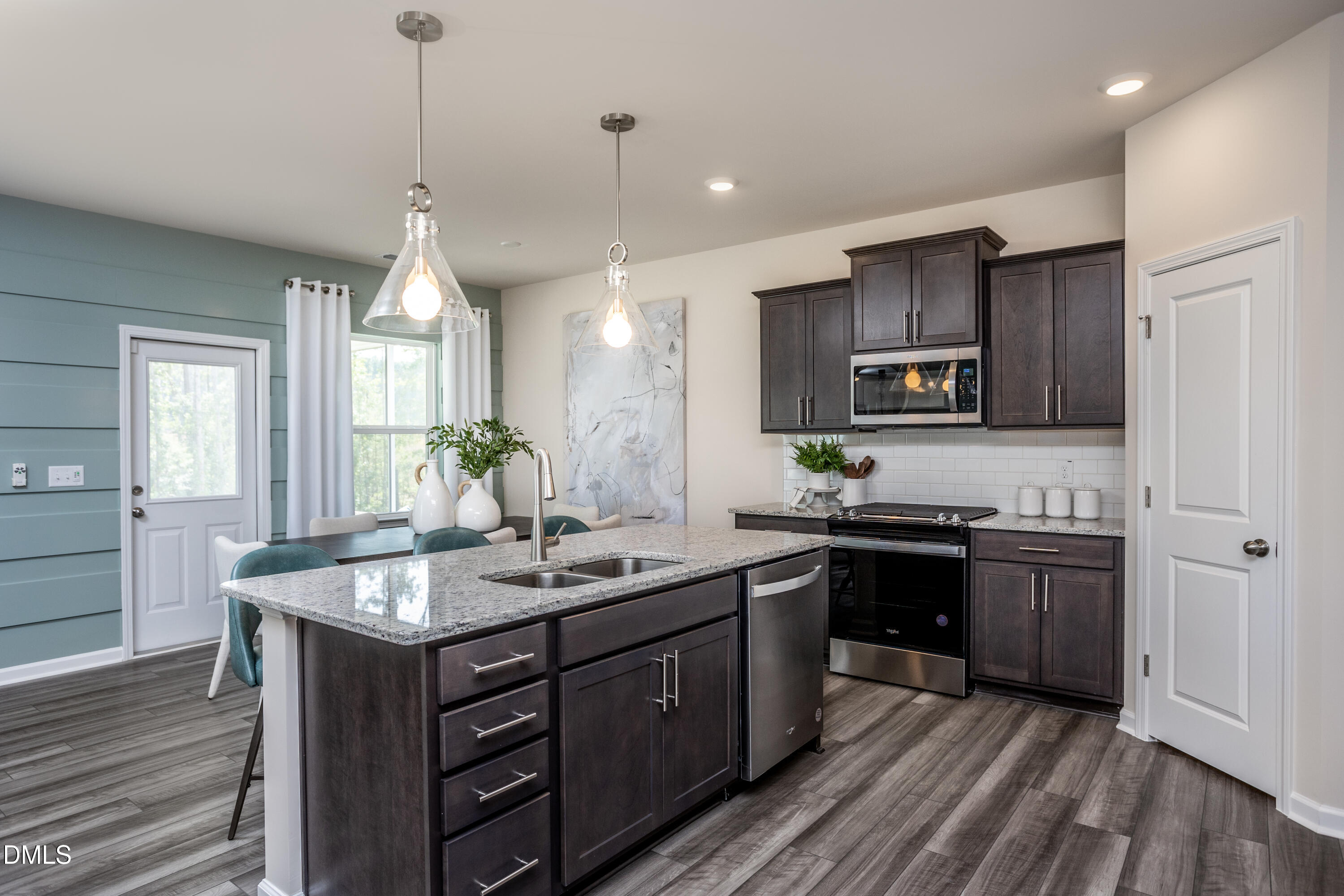 636 Fosterton Cottage Way Raleigh, NC 27603 - Photo 3 of 29 a kitchen with kitchen island granite countertop a sink stove and wooden cabinets