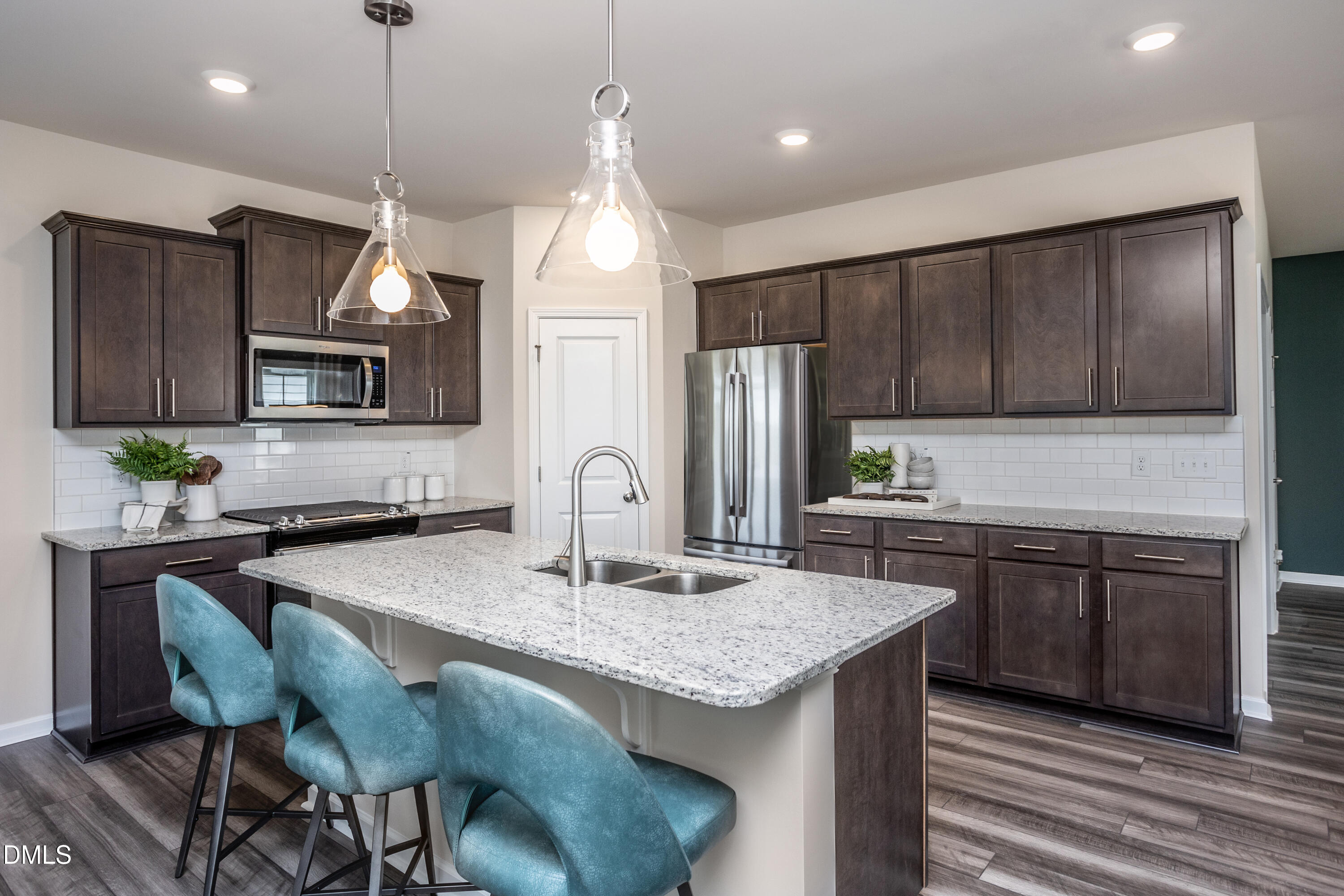 636 Fosterton Cottage Way Raleigh, NC 27603 - Photo 4 of 29 a kitchen with granite countertop a table chairs microwave and refrigerator