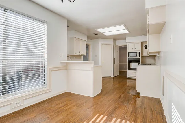 a view of a kitchen with wooden floor and a sink