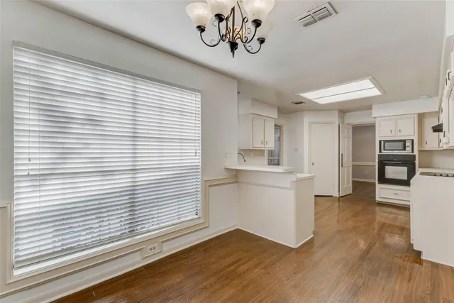 a kitchen with a refrigerator and a wooden floor