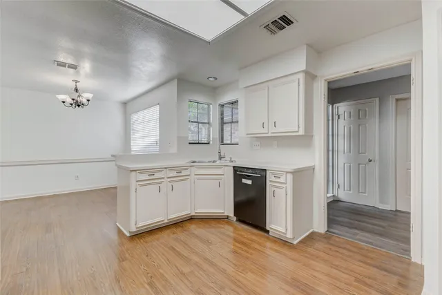 a kitchen with granite countertop a stove top oven sink and cabinets