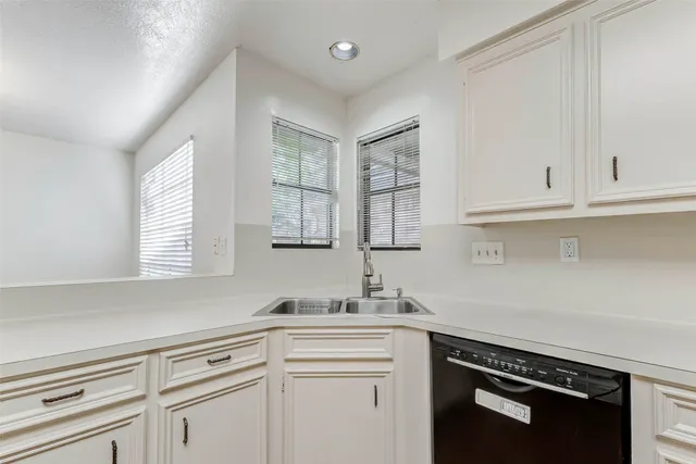 a kitchen with granite countertop white cabinets and white appliances