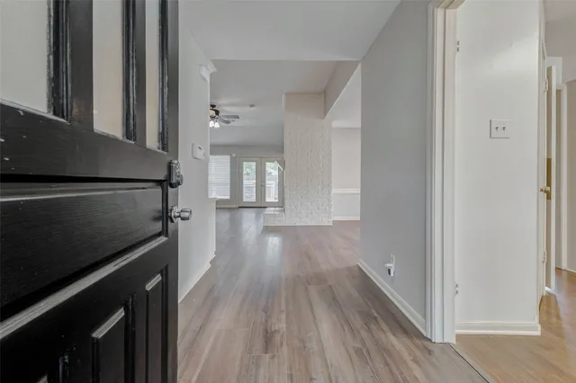 a view of a hallway with wooden floor and staircase