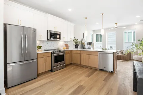 a kitchen with a refrigerator a sink and a stove top oven