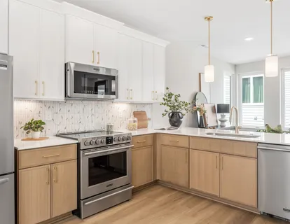 a kitchen with cabinets stainless steel appliances a sink and wooden floor