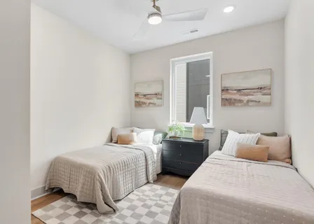 a bedroom with two beds and a large window