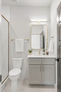a bathroom with a toilet a sink a vanity and mirror