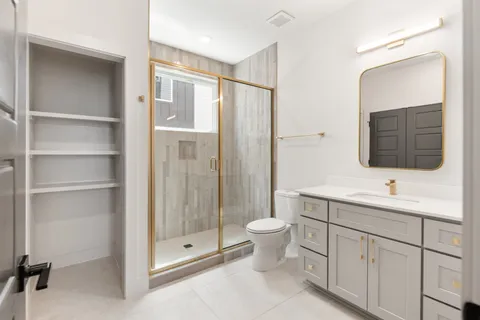 a bathroom with a toilet sink double vanity and mirror