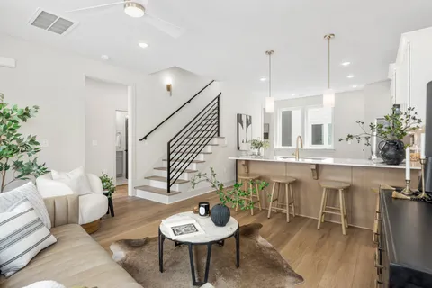 a living room with furniture kitchen view and a potted plant