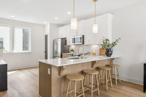 a kitchen with kitchen island granite countertop a sink and refrigerator