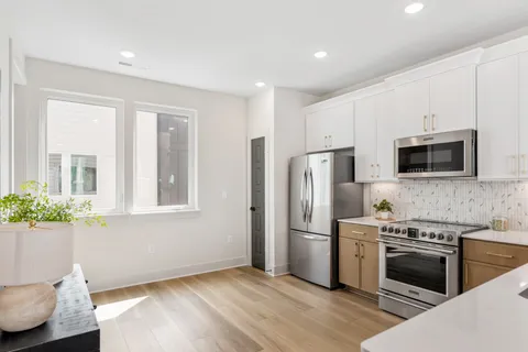 a kitchen with stainless steel appliances kitchen island granite countertop a refrigerator and a stove top oven