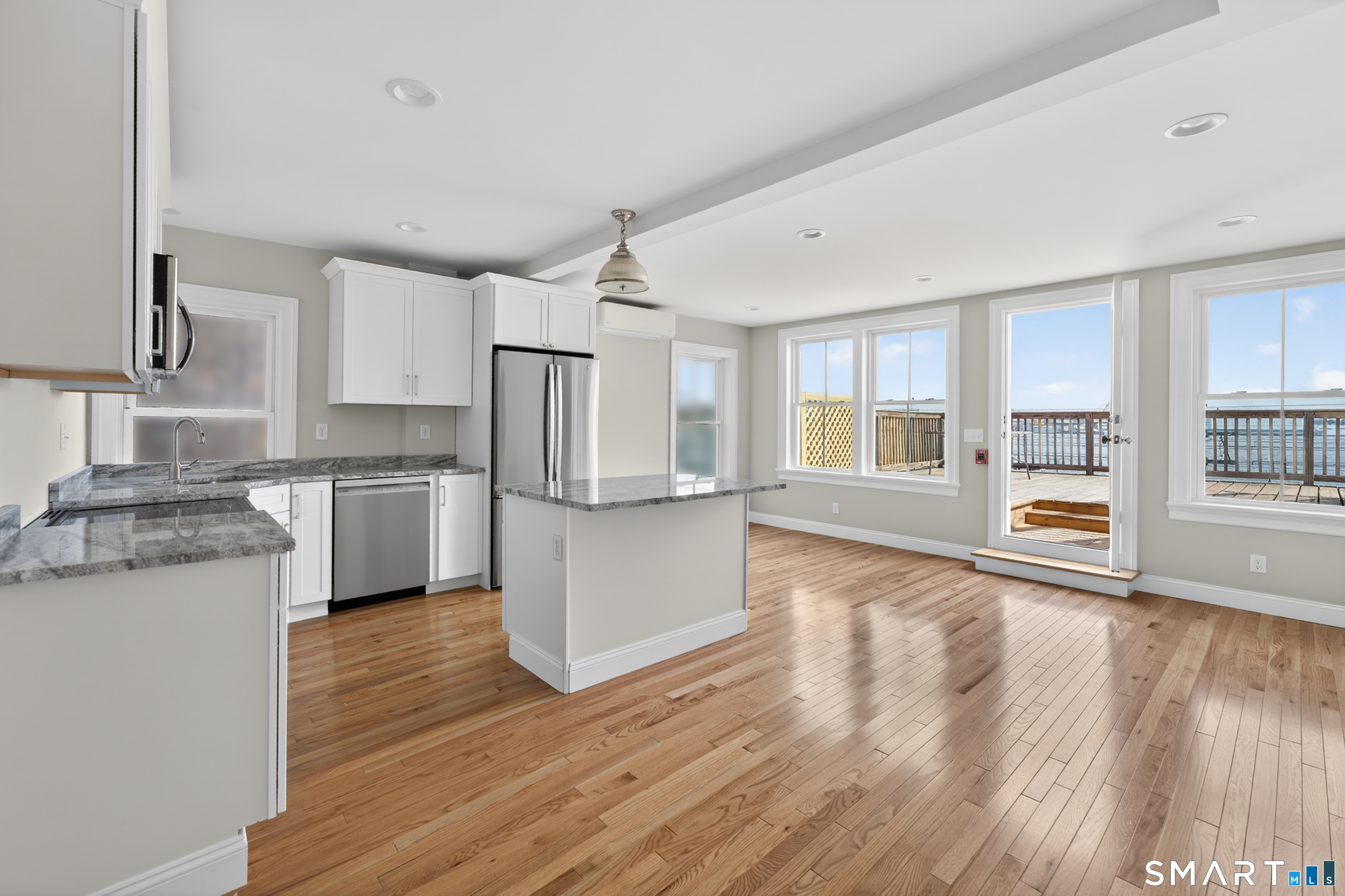 138 Bank Street, Unit 2A New London, CT 06320 - Photo 6 of 22 a kitchen with stainless steel appliances granite countertop a refrigerator a stove oven and white cabinets with wooden floor