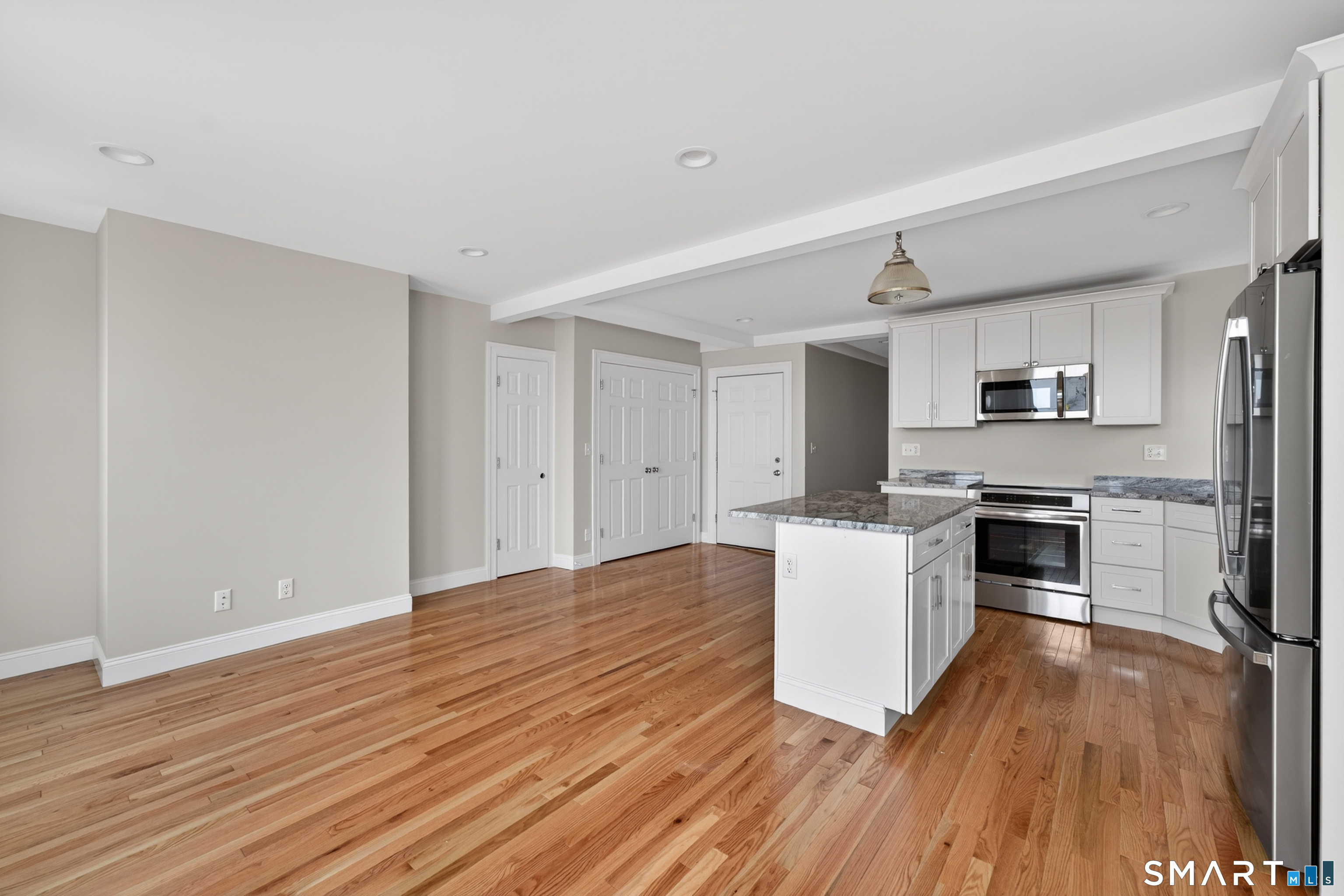 138 Bank Street, Unit 2A New London, CT 06320 - Photo 9 of 22 a kitchen with wooden floors and white appliances