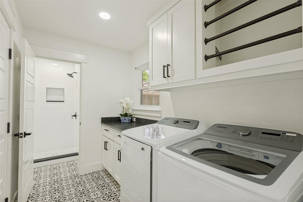 4316 Springbranch Drive Benbrook, TX 76116 - Photo 21 of 39 Laundry room featuring patterned tile flooring, a dark countertop, white cabinetry with black hardware, and an integrated shower with white subway tile