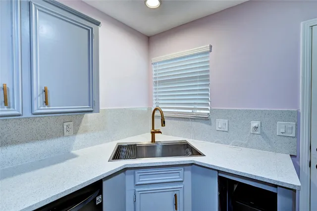 a kitchen with a sink cabinets and a window