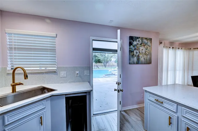 a kitchen with a sink cabinets and a window