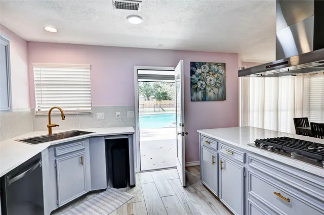 a kitchen with a sink stove top oven and cabinets