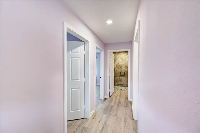 a view of a hallway with wooden floor