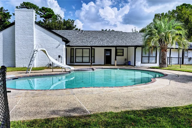 a view of a house with swimming pool and a yard