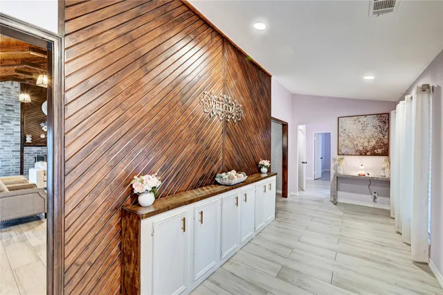 a hallway with a large window and furniture