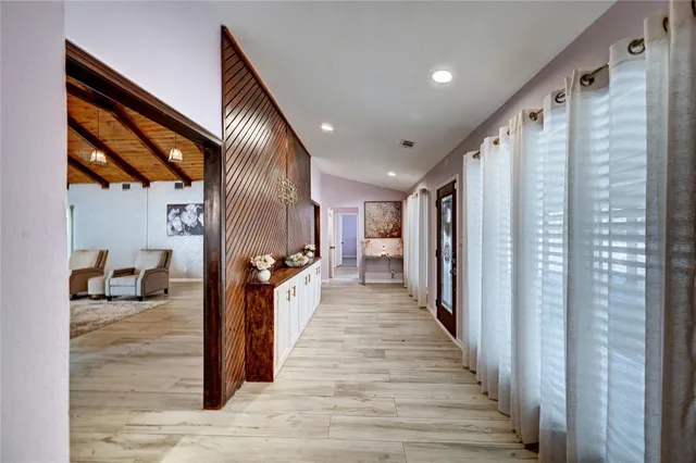 a view of a hallway with wooden floor and staircase
