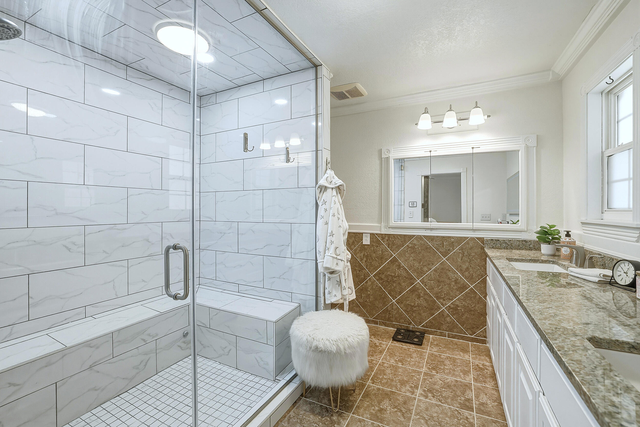 4210 44th Street Lubbock, TX 79413 - Photo 16 of 28 a bathroom with a granite countertop sink a mirror and shower