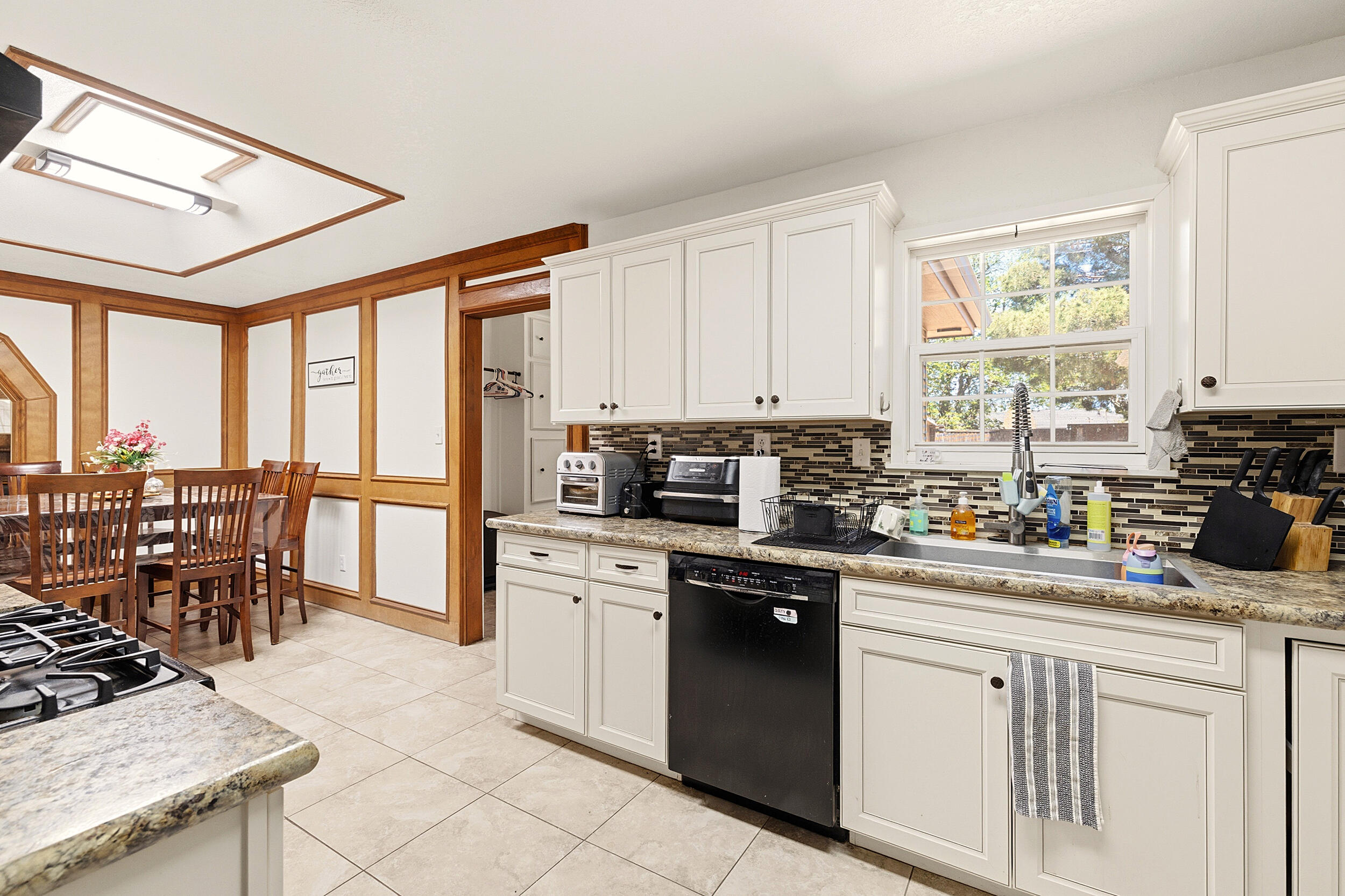 4210 44th Street Lubbock, TX 79413 - Photo 9 of 28 a kitchen with a stove a sink a dining table and chairs