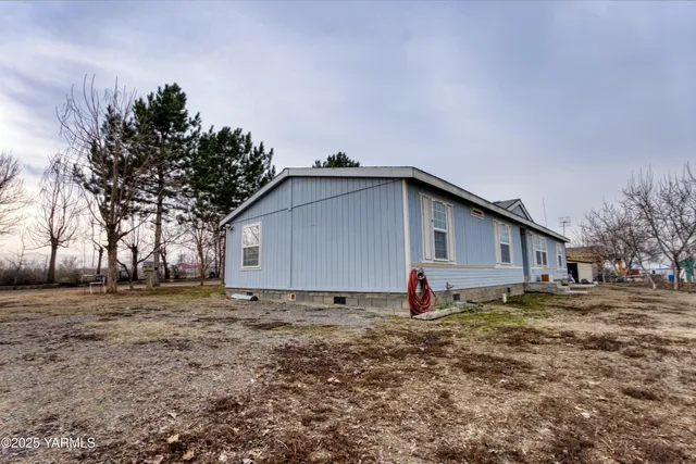 a view of a house with backyard and trees