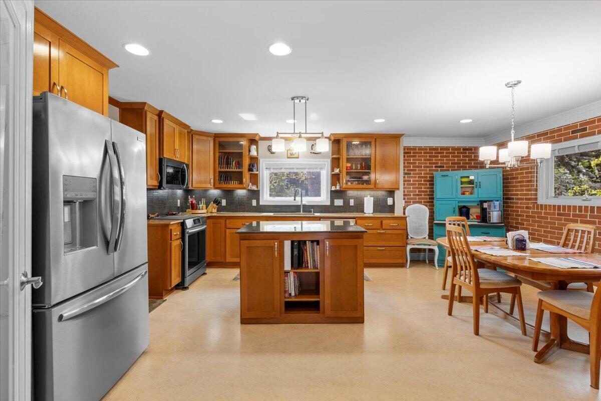 440 Bush Street Central Point, OR 97502 - Photo 15 of 40 a kitchen with stainless steel appliances granite countertop a refrigerator a stove a sink a dining table and chairs