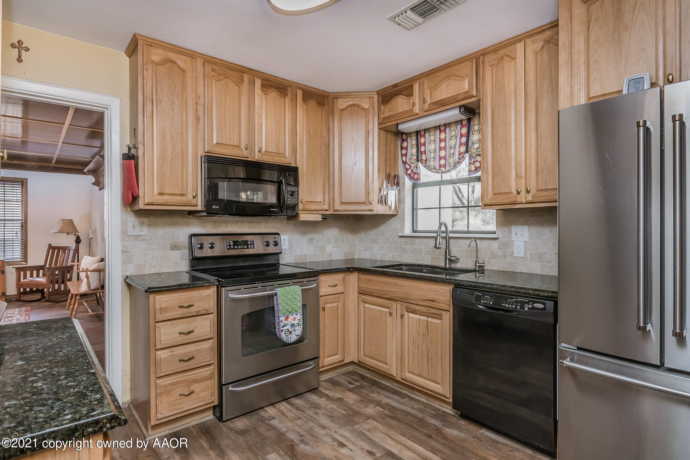 719 McKenzie Road Amarillo, TX 79118 - Photo 7 of 32 a kitchen with stainless steel appliances granite countertop a stove a refrigerator and a microwave