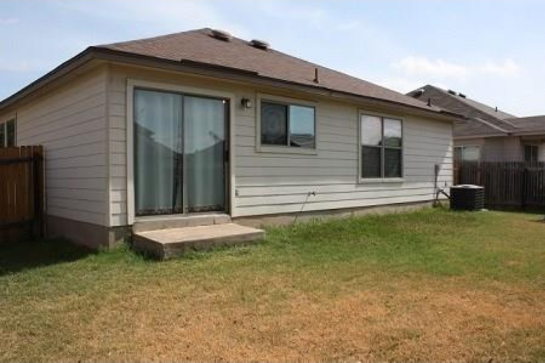 1120 Apollo Circle Round Rock, TX 78664 - Photo 6 of 14 Rear exterior featuring horizontal siding, a brown shingle roof, a sliding glass door, a concrete landing, and multiple windows