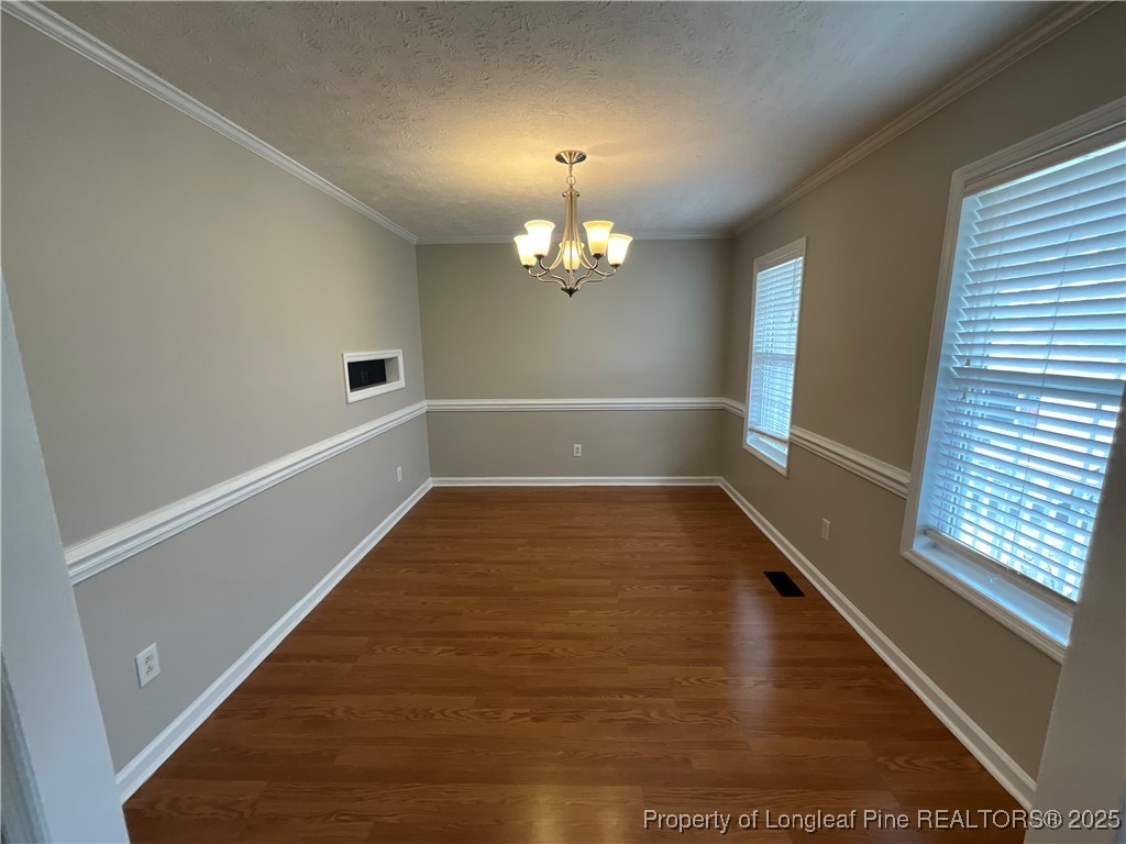 209 Pecan Trace Road Raeford, NC 28376 - Photo 3 of 24 a view of a room with wooden floor and chandelier