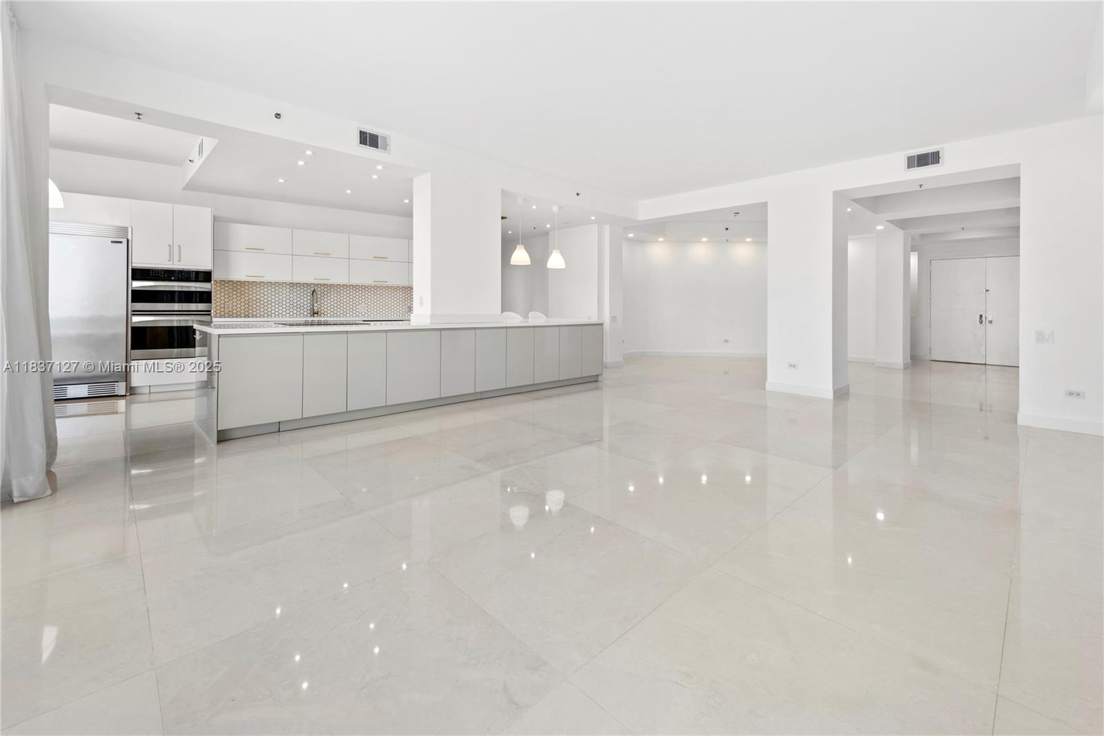 Brickell Miami, FL 33131 - Photo 18 of 65 a large white kitchen with white cabinets and stainless steel appliances