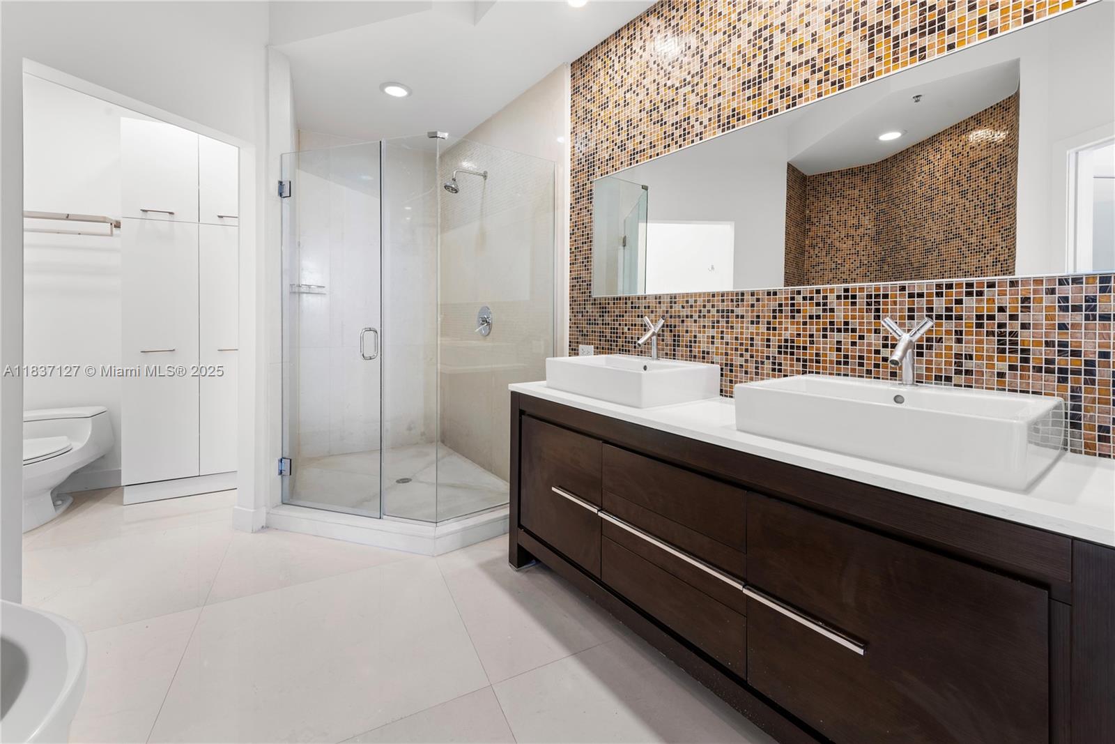 Brickell Miami, FL 33131 - Photo 39 of 65 a bathroom with a sink a toilet and shower