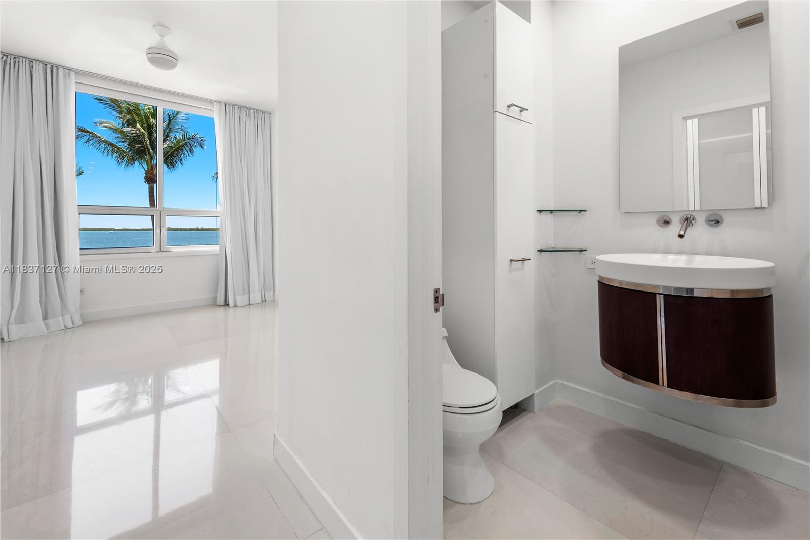 Brickell Miami, FL 33131 - Photo 49 of 65 a bathroom with a toilet sink and mirror