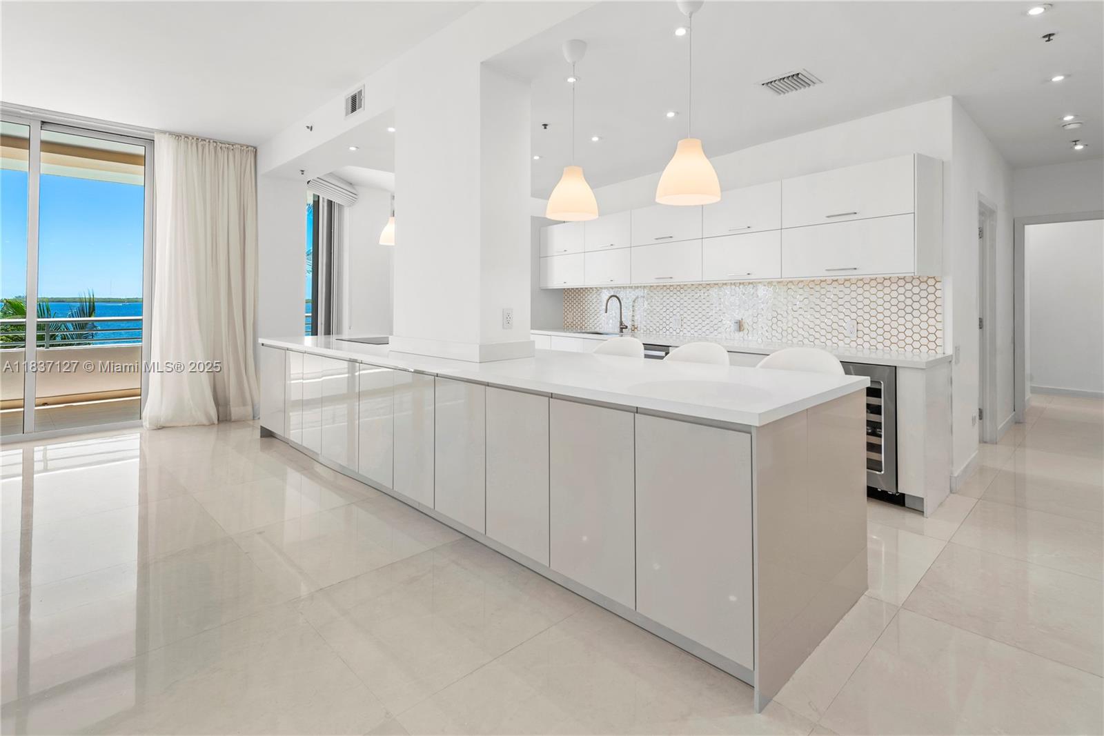 Brickell Miami, FL 33131 - Photo 7 of 65 a large white kitchen with a sink and chandelier