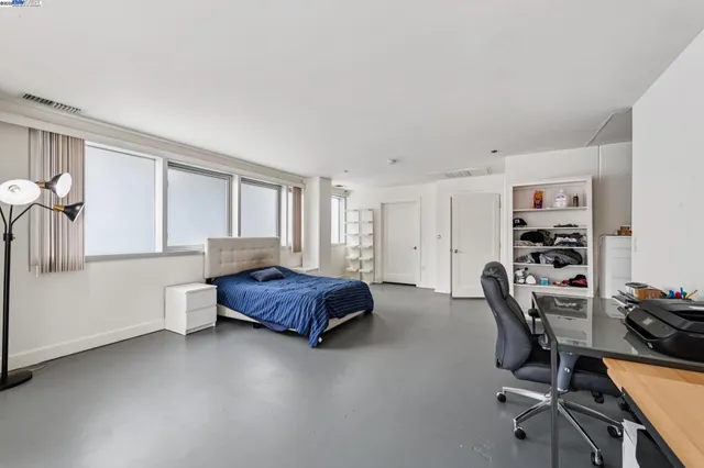 a spacious bedroom with a bed couch and a large window