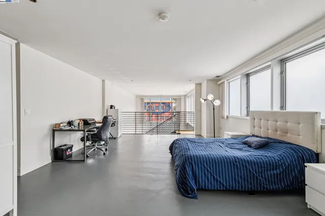 a bedroom with a large bed and wooden floor