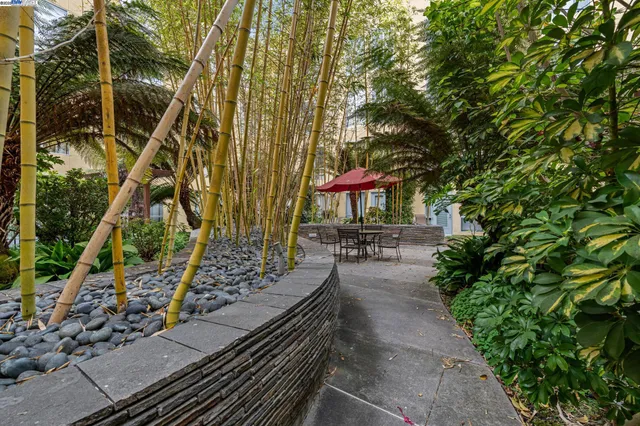 a view of a table and chairs under an umbrella in backyard
