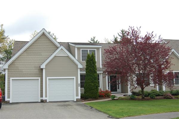 a view of a house with a yard and large tree