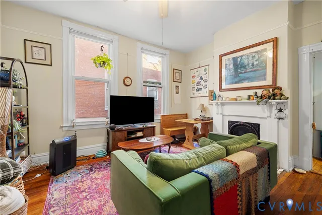 a living room with furniture a flat screen tv and a fireplace