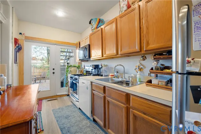 a kitchen with stainless steel appliances granite countertop a stove a sink dishwasher and cabinets with wooden floor