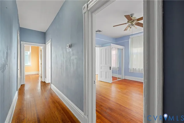 a view of a hallway with wooden floor and closet