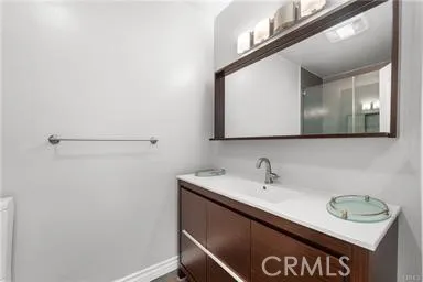 a close view of a sink a mirror and cabinets