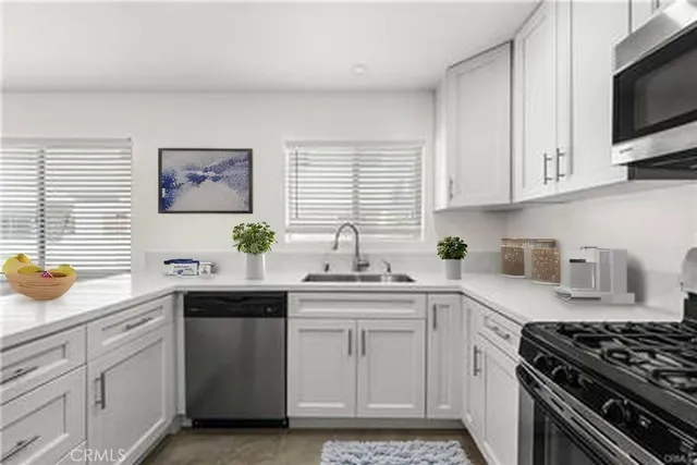 a kitchen with stainless steel appliances a sink stove and cabinets