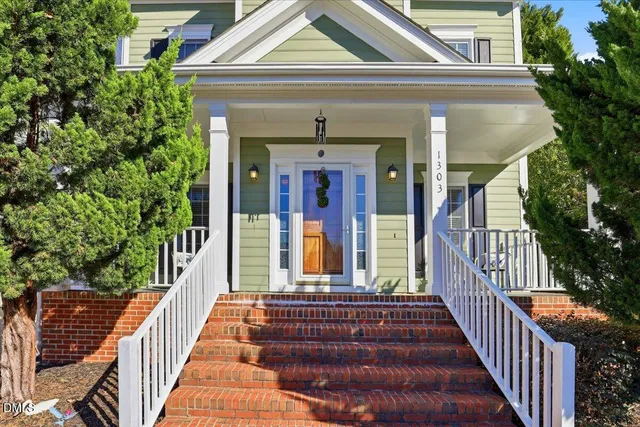 a front view of house with yard and trees in the background